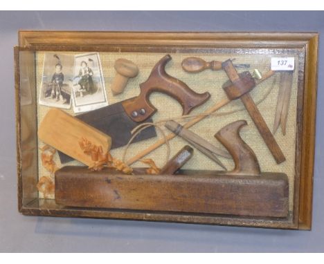A glass display case with vintage carpentry tools.
