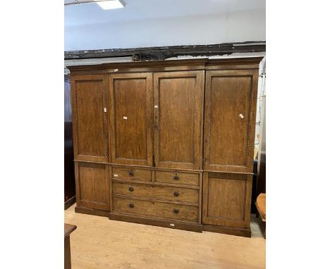 A late 19th early 20thc  Waring &amp; Gillow style mahogany breakfront wardrobe with dental cornice over central linen cabine