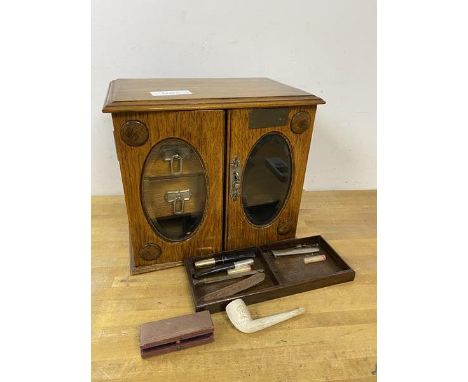 An early 20thc table top smokers cabinet with arrangement of drawers and compartments to interior, hinged top bears brass pla