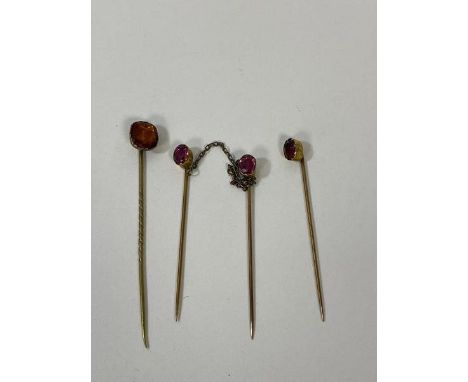 A set of three yellow metal stick pins with amethyst finial's with orange coloured stone, measures 7cm (4)