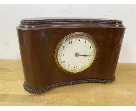 A late 19th early 20thc mahogany mantel clock of kidney shape with beaded top and moulded base on squat bun feet, dial inscri
