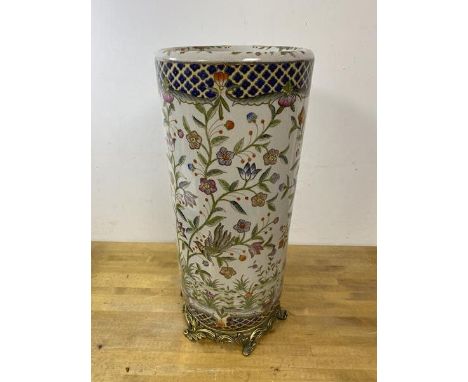 A modern china umbrella or stick stand, the cylindrical body with floral and bird decoration on foliate metal base, measures 