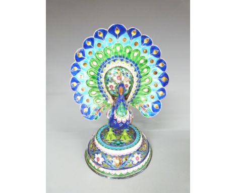 A white metal model of a peacock with enamel decoration, 25cm tall
