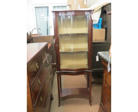 An early 20th century mahogany display cabinet, serpentine-shaped glazed door enclosing lined interior with two shelves, open