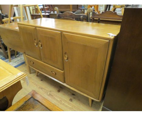 An Ercol light elm sideboard, enclosed by three cupboard doors and single drawer, complete with Ercol cutlery tray, 3ft. 9in.