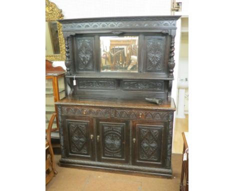 A large late 19th century Flemish-style dresser, upper stage with bevelled mirror and single shelf, panelled cupboard base wi