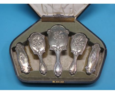 An Edward VII silver dressing set, pair of hairbrushes, pair of clothes brushes, bevelled hand-mirror and comb, Chester 1904,