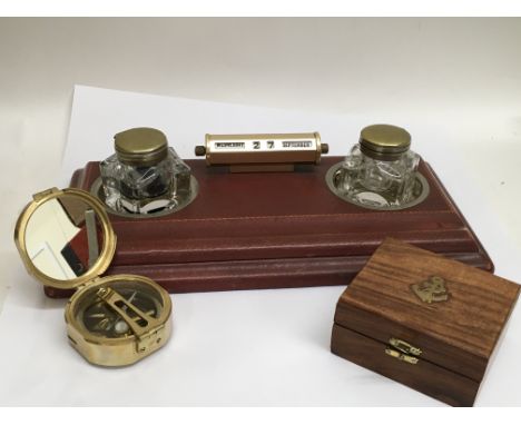 A leather desk top with a pen and inkwell holder and inkwells, with a date scroll and a reproduction compass, cased.