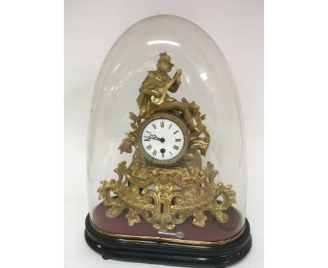 A French gilt metal Spelter clock the top with a figure playing a lute. No pendulum or key under a glass dome. Hight 45cm.