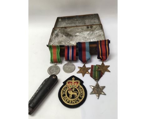 A collection of Second World War medals and an old pocket knife, all in an old Cadbury’s tin.