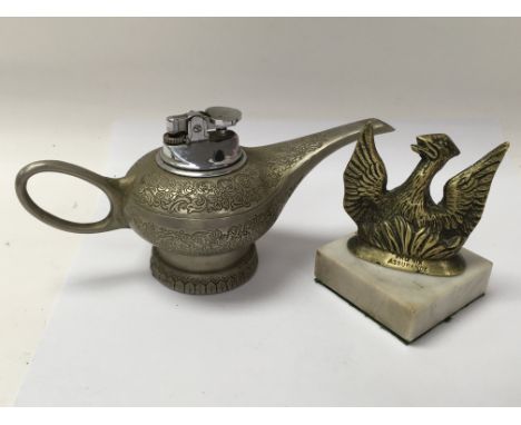 A vintage table lighter in the form of Aladdins lamp, and a small brass Phoenix advertising figure for Phoenix Assurance on a