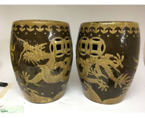 A pair of brown glazed Chinese garden seats decorated with dragons, height 45cm no obvious damage. (2)