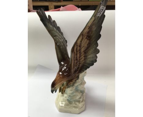 A large ceramic figure of an eagle perching on a rock. No reserve.