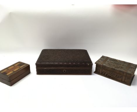 An old profusely carved box, a smaller carved box and a cribbage box with counters and cards.