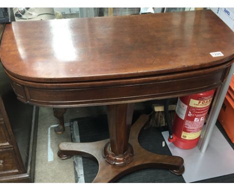 An Early Victorian mahogany card table with a hinged top on a pillar support and platform base.