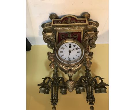 A Roman numeral mantel clock with French Victorian influence. Additionally it has a pair of matching four arm candelabra. App
