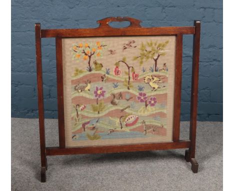 A Oak framed tapestry fire guard depicting a garden/animal scene ( 75cm width 75cm height)  
