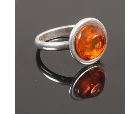 A Silver/white metal ring with large amber cabochon  