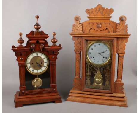 A carved light oak gingerbread clock along with a mahogany mantel clock example.  