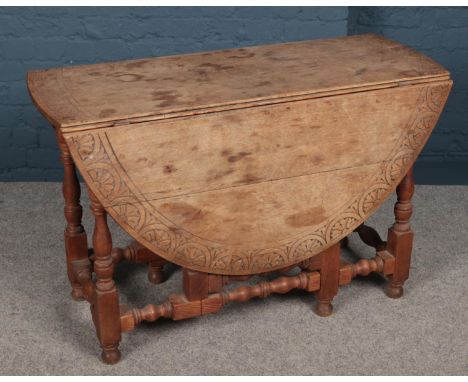 A carved light oak dropleaf table.  Split to table top.