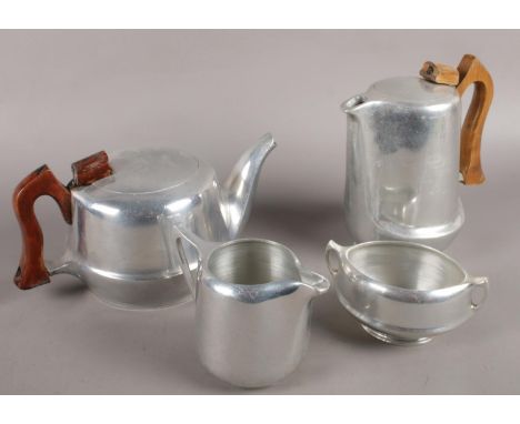 Four pieces of picqout ware to include teapot, coffee pot, milk jug, etc.  Surface scratches. No dents. Wear to wooden handle