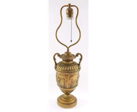 A neoclassical late 19thC loaded brass table lamp, of twin handled semi fluted urn form, decorated centrally with a frieze em