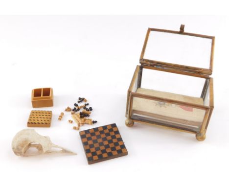 A miniature glass casket, containing a miniature chess set, No 17., by A J Winfield-Chijcott, October 1978., a bird's skull a