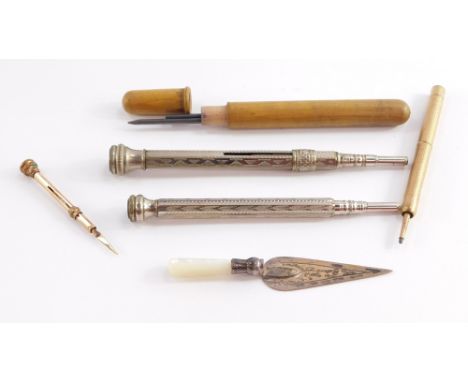 A silver and mother of pearl handled trowel form page marker, three propelling pencils, and a gold plated toothpick.
