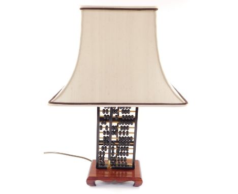 A Chinese abacus form table lamp, raised on a wooden base, with shade, 59cm high.