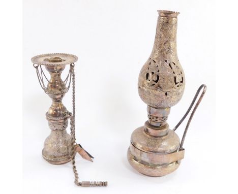 An Egyptian silver oil lamp, with pierced and engraved foliate decoration, 22.5cm high, and a silver candle holder with wick 