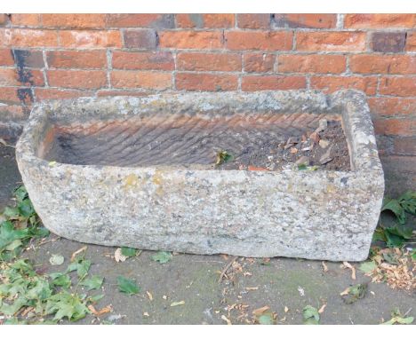 A hand hewn bull-nose stone trough, 30cm H, 110cm W, 47cm D.