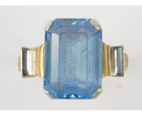 An aquamarine solitaire ring, emerald cut in white and yellow metal, size K, 5.6g.