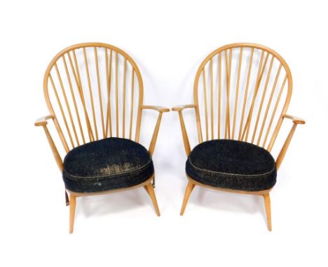 A pair of Ercol beech and elm stick back fireside chairs, with cushion solid seats, raised on turned legs united by an H fram