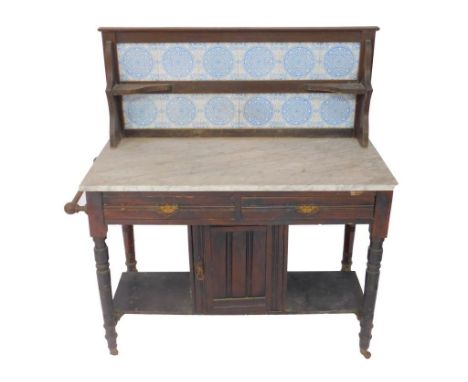 A Victorian stained pine and marbled topped washstand, with blue tiled splash back over two frieze drawers above a cupboard a