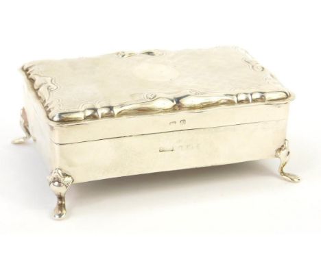 An Edward VII silver jewellery casket, of rectangular form, with an engine turned serpentine hinged lid, with circular reserv