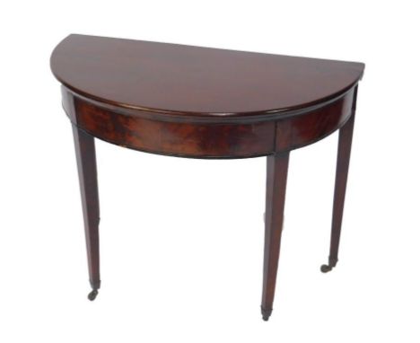 A George IV mahogany demi lune fold over card table, raised on tapering square legs, capped on castors, 73cm H, 91c, W, 45cm 