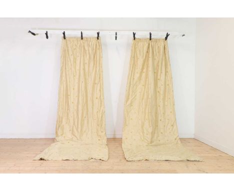 A pair of embroidered silk curtains,the pale gold ground delicately embroidered with trailing stems and yellow velvet flower 