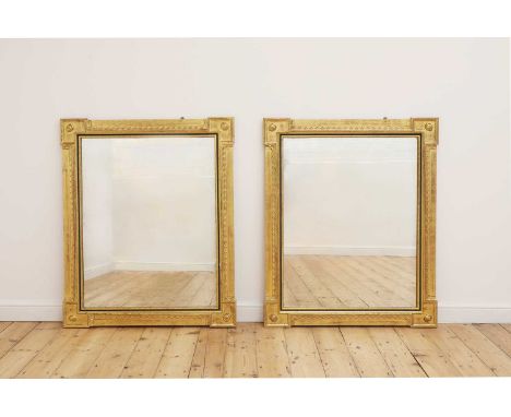 A pair of giltwood and ebonised mirrors,of recent manufacture, each of shaped rectangular outline, with moulded detail and th