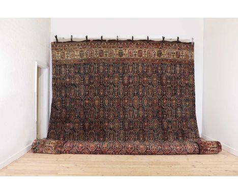 A very large Persian wool carpet,20th century, the central field woven with repeating paisley motifs, within multiple geometr