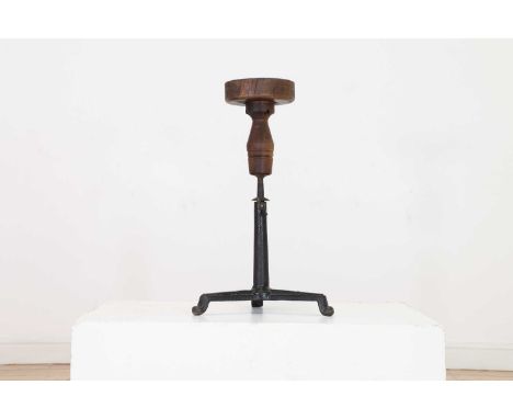 An adjustable oak sculpture stand,19th century, the circular platform top supported by a cast iron column and tripod base,41c