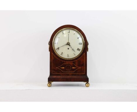 A Regency mahogany and inlaid bracket clock,the circular dial set with Roman numerals, within an arched case, raised on bun f
