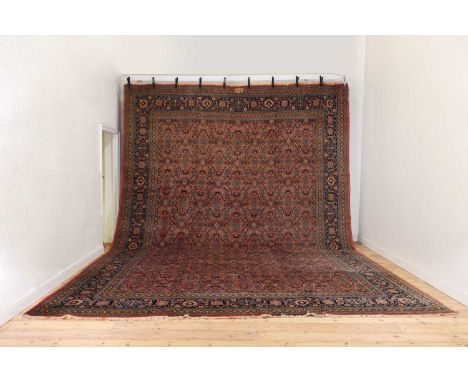 A large wool Persian carpet,early/mid-20th century, in the manner of the Benlian workshops, with floral and foliate motifs on