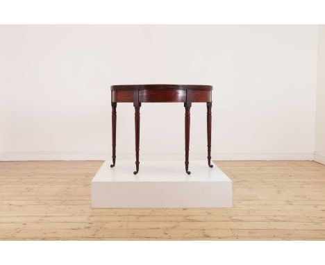 A George III mahogany demilune card table, c.1810, raised on four turned and tapered legs, set into an apron and terminating 