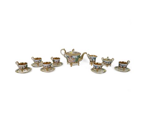 A Capodimonte tea service relief decorated in polychrome glaze with putti in a landscape setting, with gilt lining and detail