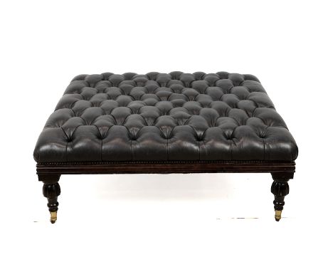 Large square button-back leather footstool. Turned, stained hardwood base on castors with black leather upper. W 104cm, D 104