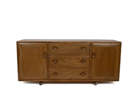 Mid Century Ercol light elm sideboard. Three central drawers flanked by two cupboards, on castors. W 155cm, D 45cm, H 69cm.