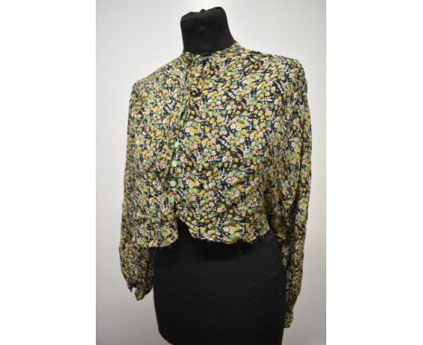 A 1930s floral crepe blouse, having bow to neckline and long sleeves, has been historically shortened and requires hemming.