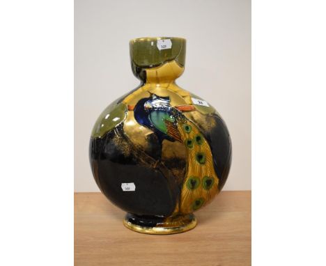 An early 20th century Thomas Forrester &amp; co vase of flask shaped form, having peacock design and extensive gilt heighteni