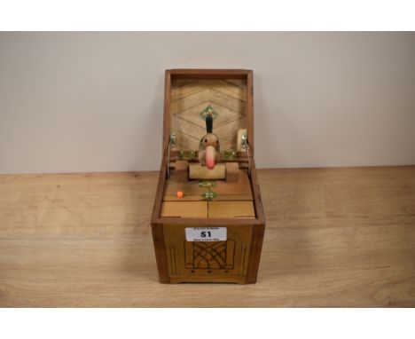A vintage mechanical musical pop up bird in a box cigarette dispenser