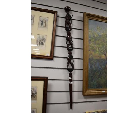 A vintage African carved walking cane, depicting heads.